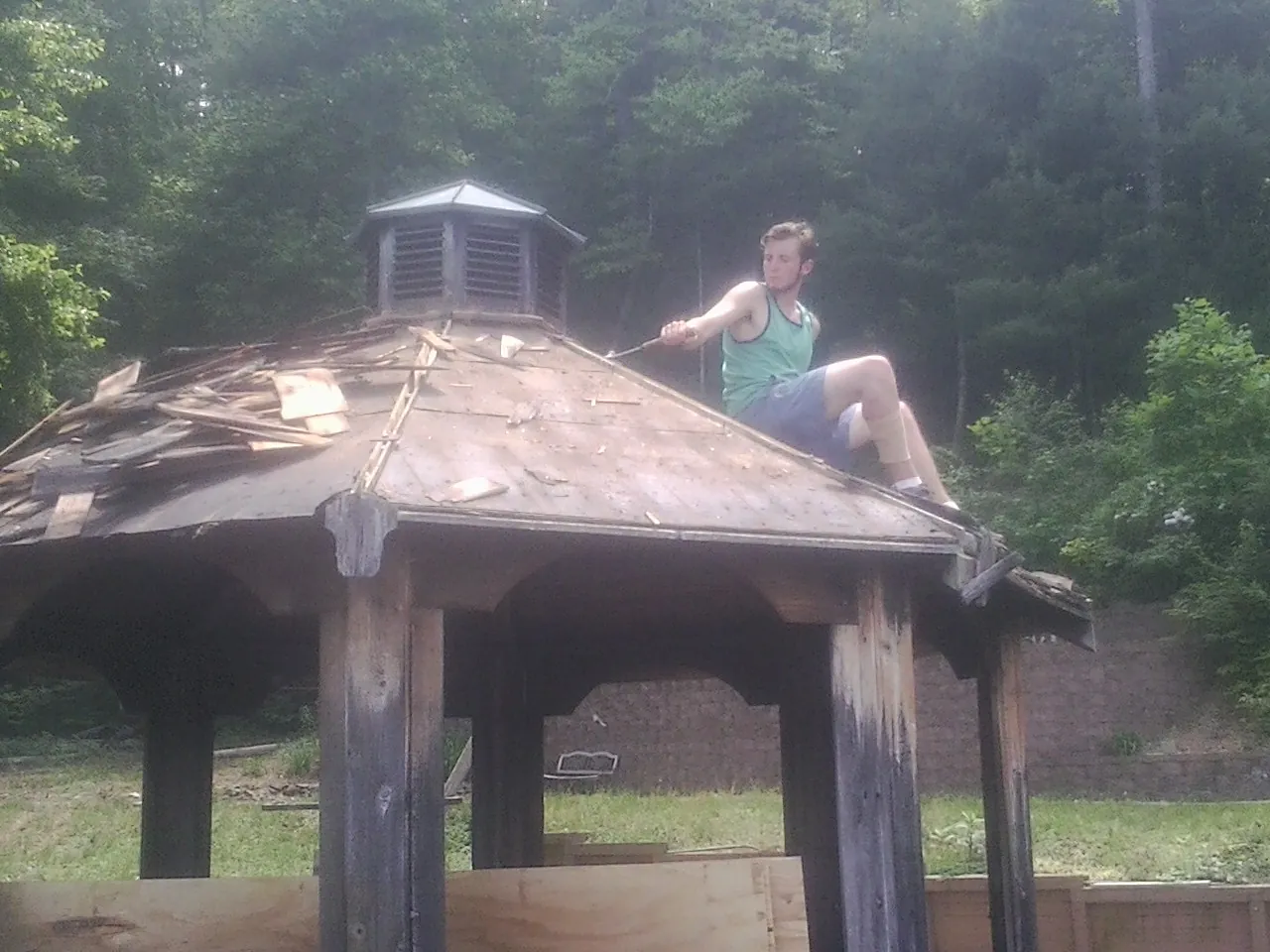 Tearing the old roof off a wooden gazebo before new shakes in Happy Valley