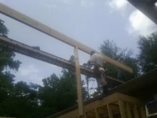 Carpenter setting a ridge beam over a new addition frame — Ice Dam Removal by Roofing Brothers in Happy Valley