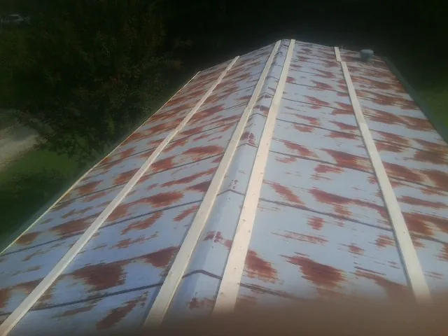 Rusted metal roof panels with new wood purlins before replacement — Storm Damage Roof Repair in Happy Valley by Roofing Brothers