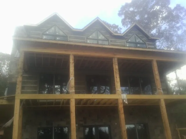 Dormers and porch framing on a large log home under construction — Roof Coating work by our crew in Happy Valley