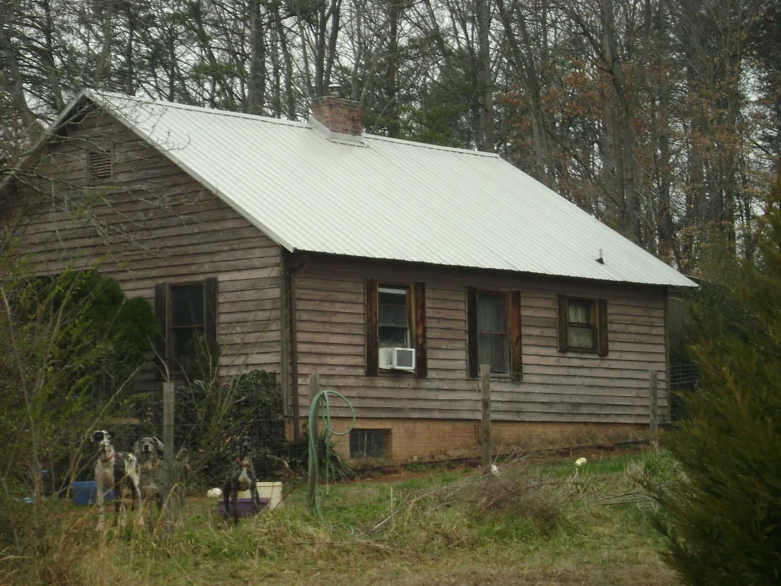 White metal roof on an old wood sided farmhouse, from a Metal Roof Installation job in Happy Valley